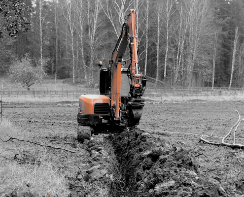 Industrial motor grader and backhoe excavator on highway constru